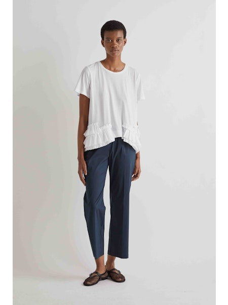 Someone wearing MEIMEIJ Pull On Cotton Pant in Black, a white top, and black open-toe sandals stands against a plain light background.