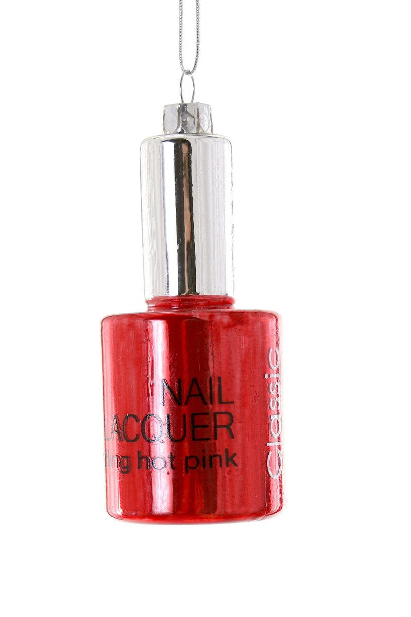 A glass bottle labeled "NAIL POLISH ORNAMENT" from CODY FOSTER, standing at 3.75 inches tall, hangs from a silver string. The metallic silver cap catches the light with its elegant reflection.