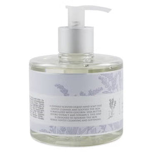 A clear pump bottle labeled "EUROPEAN SOAPS, LLC" contains lavender-scented HERITAGE LIQUID SOAP enriched with glycerin. The label features lavender plant illustrations and text in both English and French. The light purple liquid soap inside adds to the packaging's elegant and minimalistic appeal.