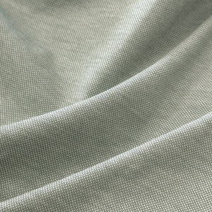 A man with short dark hair and a beard wears sunglasses and the COLLARS AND CO - PALM PIMA BLEND QUARTER ZIP IN MINT over a white collared shirt, leaning against a light-colored wall outdoors, showcasing modern comfort in this pullover.