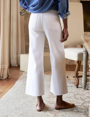 A pair of white high-waisted wide-leg Galway Gaucho jeans by FRANK & EILEEN, featuring front and back pockets, belt loops, and a button and zipper closure. The FRANK AND EILEEN - GALWAY GAUCHO JEAN IN WHITE is displayed flat against a textured light background.