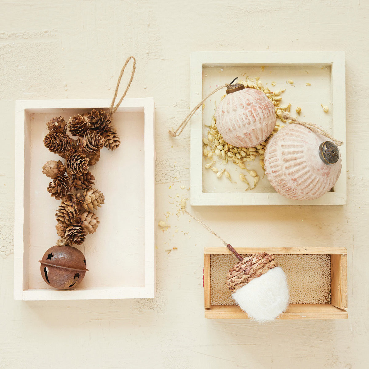 The CREATIVE COOP PINECONE CLUSTER WITH JINGLE BELL features rustic pinecones on a string with a bell—perfect as a festive door jingle, shown on a white background.