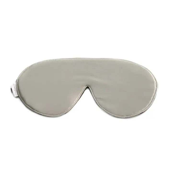 The SILVER SILK SLEEP MASK by E WIGHTMAN &amp; CO is a simple grey silk eye mask with a smooth texture, designed to block out light for better sleep. It features a slight contour to fit comfortably over the eyes and nose, along with an adjustable strap for a secure fit. A small white tag is visible on one side.