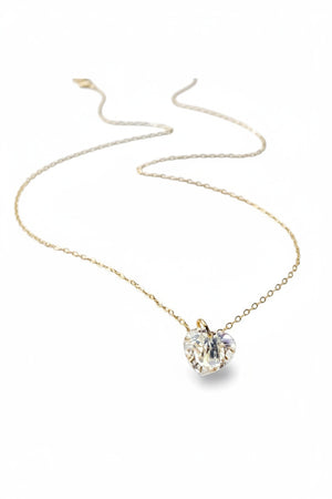 The VERDIER - AURORA CRYSTAL HEART NECKLACE from VERDIER features a sparkling crystal AB heart-shaped pendant suspended on a delicate 14k gold filled chain, shimmering against a white background.