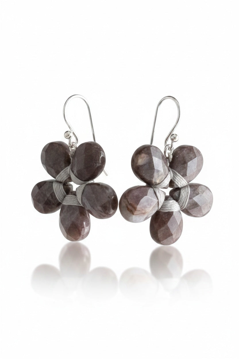 These sophisticated ANN LIGHTFOOT - Pietersite Flower Earrings showcase a graceful design with black petals complemented by sterling silver accents. Each earring is crafted with five symmetrical petals, exuding an elegant charm. Featuring convenient hooks for easy wearing, these earrings seamlessly blend style and functionality.