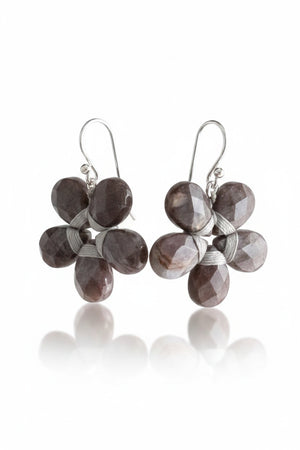 These sophisticated ANN LIGHTFOOT - Pietersite Flower Earrings showcase a graceful design with black petals complemented by sterling silver accents. Each earring is crafted with five symmetrical petals, exuding an elegant charm. Featuring convenient hooks for easy wearing, these earrings seamlessly blend style and functionality.