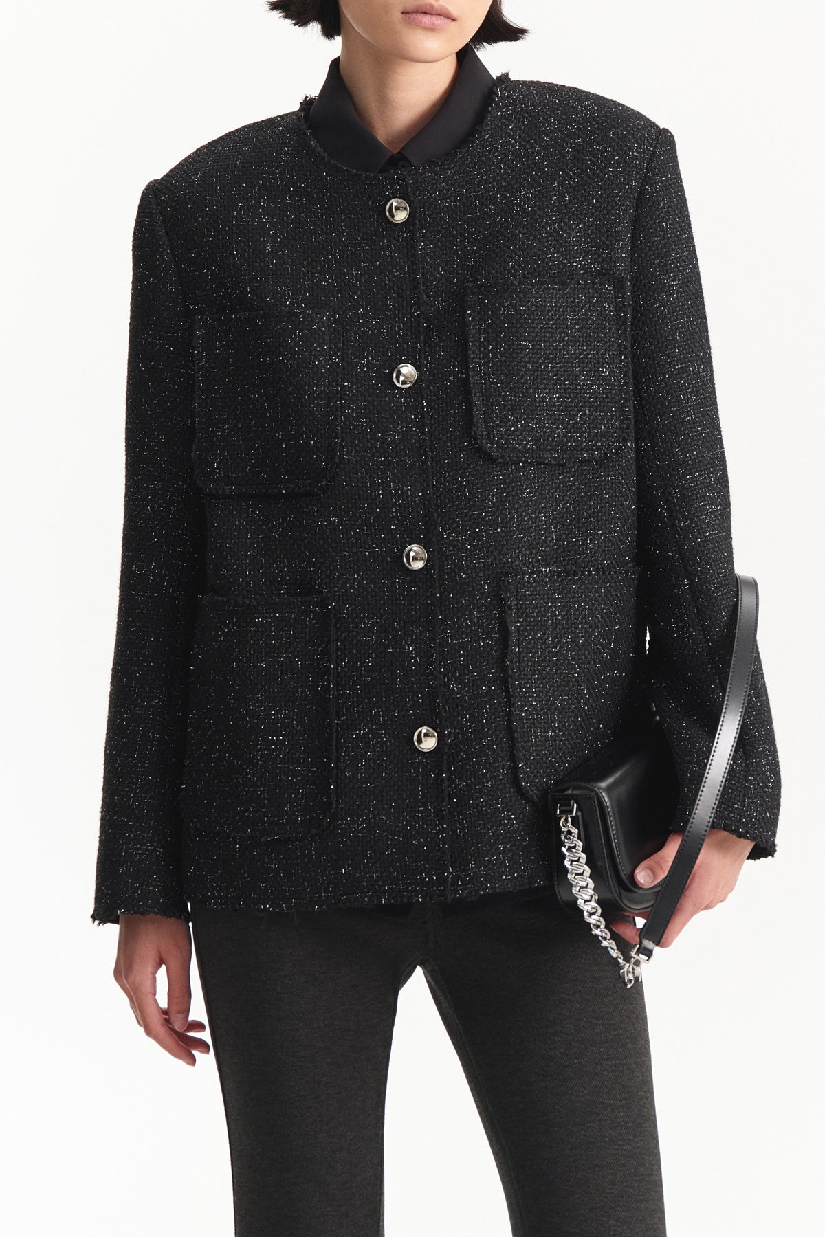 The ELEH - TWEED JACKET by ELEH features a dark, textured tweed design with four front pockets and silver buttons, reflecting modern sophistication and Italian tailoring against a plain white background.
