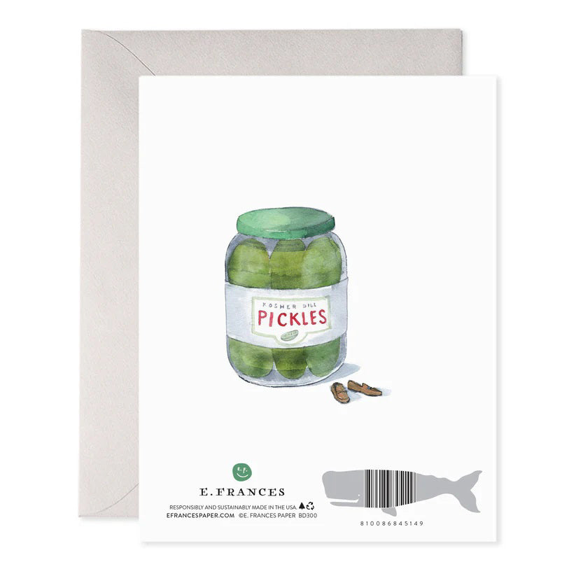 The E. FRANCES PAPER - BIG DILL GREETING CARD showcases a cartoon pickle with glasses, sitting cross-legged in an armchair, with the text: "I mean, I’m just not going to make a big dill about it. Happy Birthday." It's a charming whimsical card for any collection!.
