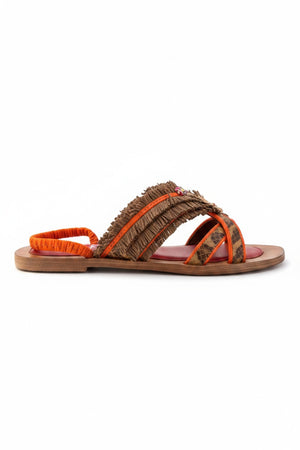 The MEHER KAKALIA - HAMAM SLIDE IN LEOPARD KHAKI sandal by MEHER KAKALIA features a flat toe-ring design with a wooden sole, vibrant red insole, orange heel strap, and brown textured raffia upper straps adorned with decorative accents.