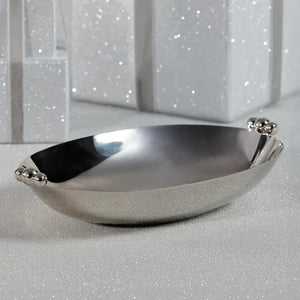 The ZODAX POLISHED NICKEL SERVING BOWL is a shiny, oval-shaped silver decorative bowl featuring two polished nickel round handles on opposite sides, displayed against a white background.