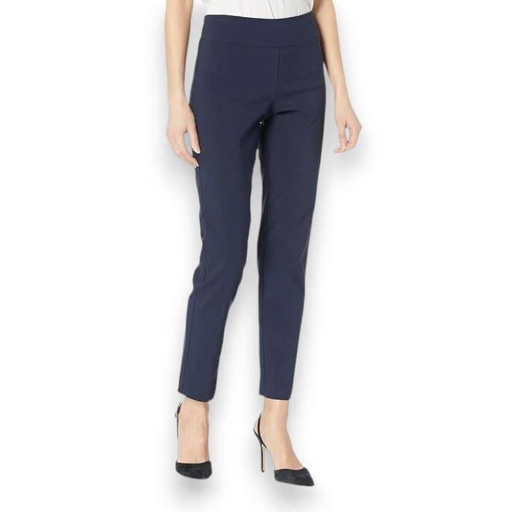 A person is wearing KRAZY LARRY, INC&#39;s PULL ON ANKLE PANT in a slim fit beige straight-leg style and black high-heeled shoes against a white background. The outfit is completed with a sleeveless black top that reveals part of the arms and torso.