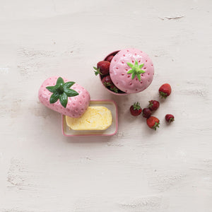 The CREATIVE COOP HAND-PAINTED CERAMIC STRAWBERRY SHAPED JAR WITH LID is a pink, strawberry-inspired storage container with a green stem handle—ideal for adding decorative charm to your kitchen.