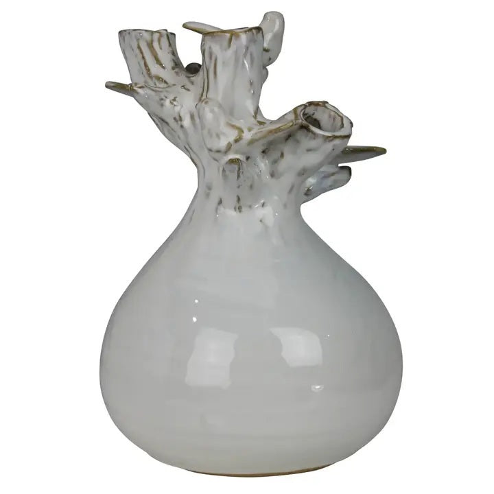 The HOMART CERAMIC VASE WITH BRANCH AND BIRD features white flowers and branches, set on a wooden surface with framed bird art and a woven basket against a light gray textured wall for a cozy touch.