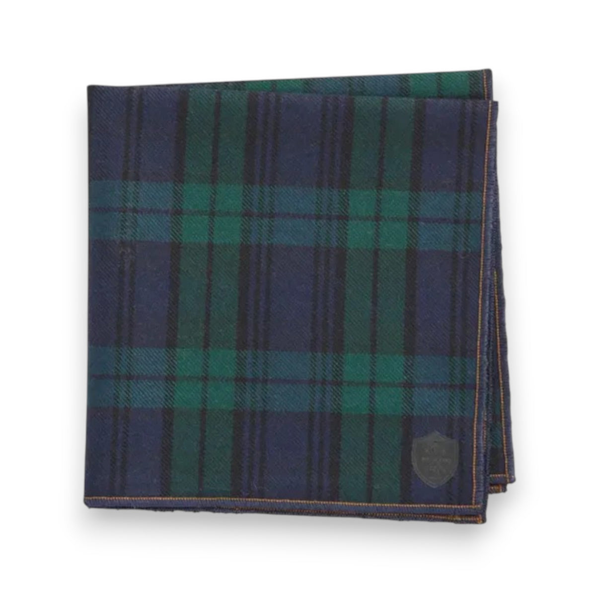 The CLIFTON WILSON - WOOL POCKET SQUARE showcases a navy blue and green plaid design with thin black lines and a small stitched emblem, making it an essential accessory for men.