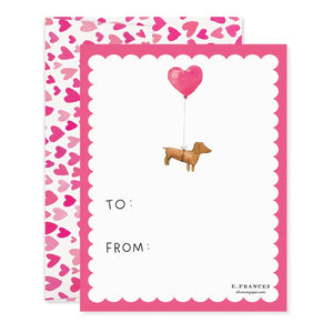 The E. FRANCES PAPER - DOGGIE DRESS-UP CLASSROOM VALENTINE SET features three dogs dressed festively: one in striped pajamas, another with a heart bandana, and a third with heart antennae. “Happy Valentine’s Day!” is displayed across the top against a backdrop of pink hearts, ideal for charming Valentines or envelopes.