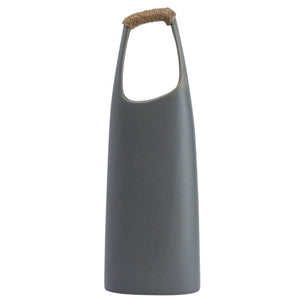 The CREATIVE COOP STONEWARE VASE WITH RATTAN WRAPPED HANDLE, GREY, stands tall with a matte finish and elongated oval opening, making a striking decorative centerpiece against a white background.