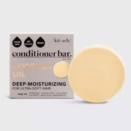 A round, beige solid conditioner bar sits on its light gray packaging labeled "KITSCH Coconut Repair Deep Conditioning Bar Mask." Infused with coconut oil for softness and shine, it detangles and conditions. The package highlights "Color Safe," "pH Balanced," "Vegan," and plastic reduction.