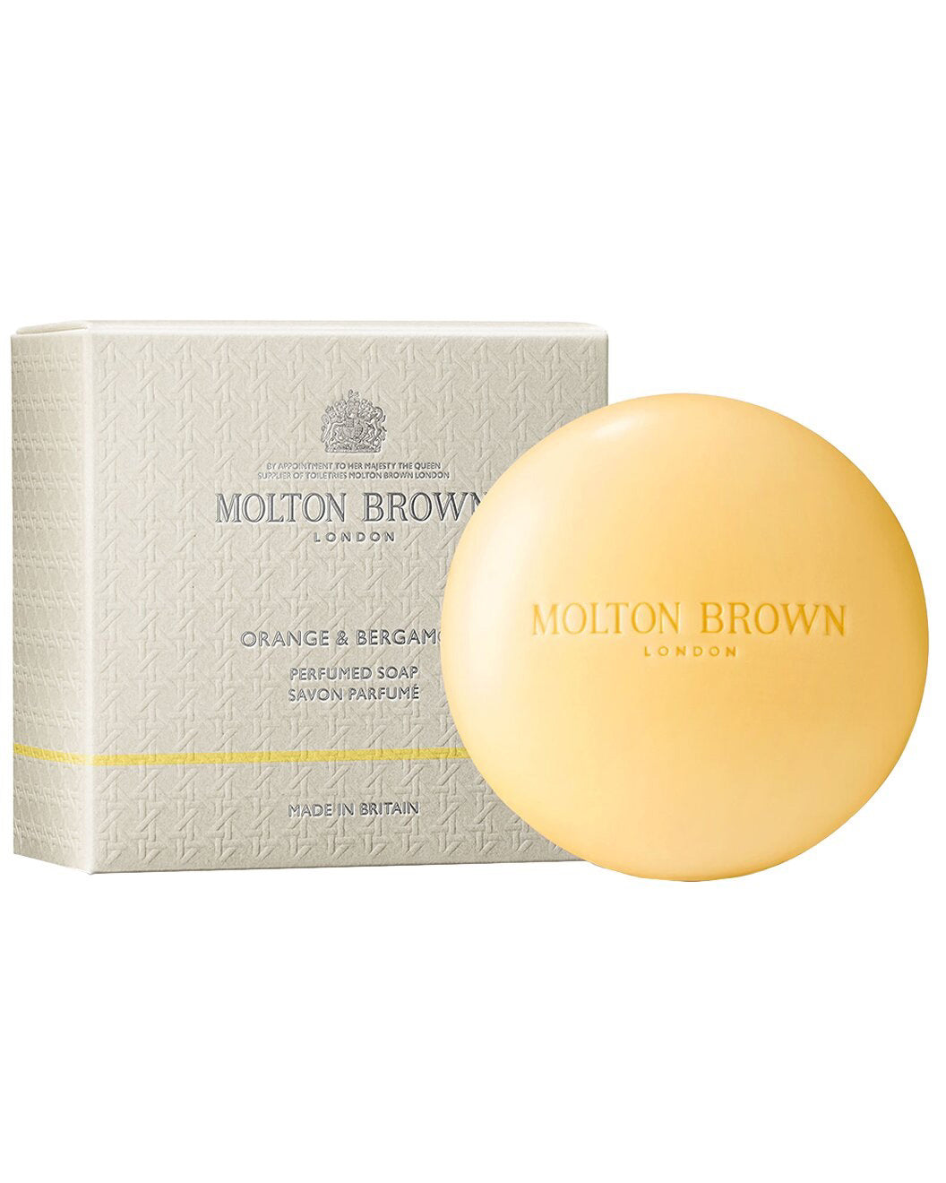 A round, pale yellow bar of MOLTON BROWN - ORANGE & BERGAMOT PERFUMED SOAP is displayed in front of its textured, light-colored box. Both the soap and packaging feature the MOLTON BROWN brand name.
