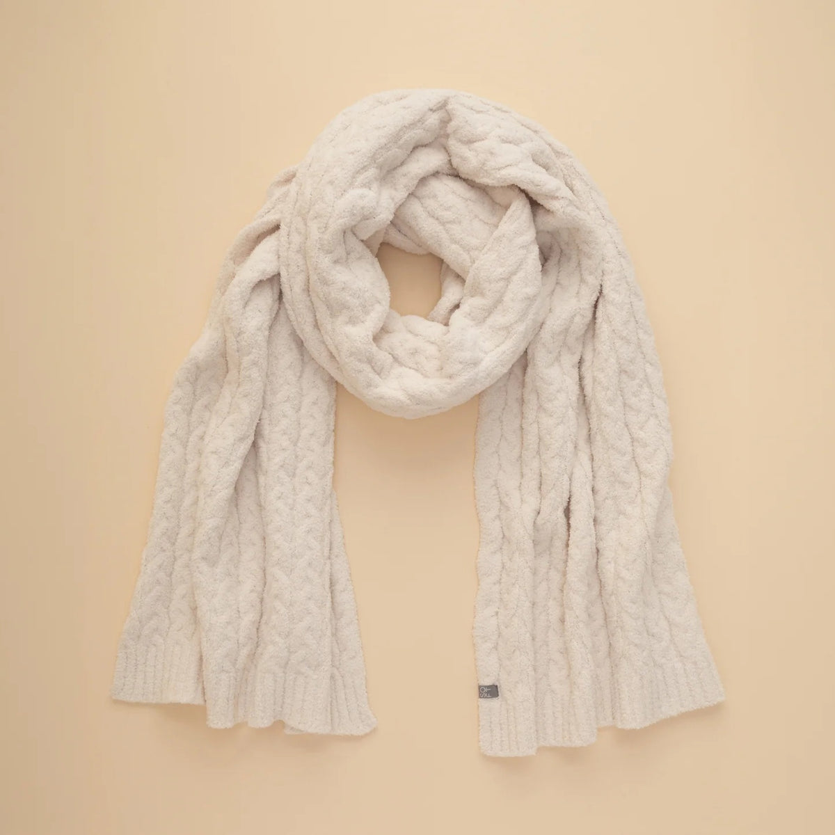 A dark navy blue SOFTIES - CABLE KNIT MARSHMALLOW SCARF draped in a loop.