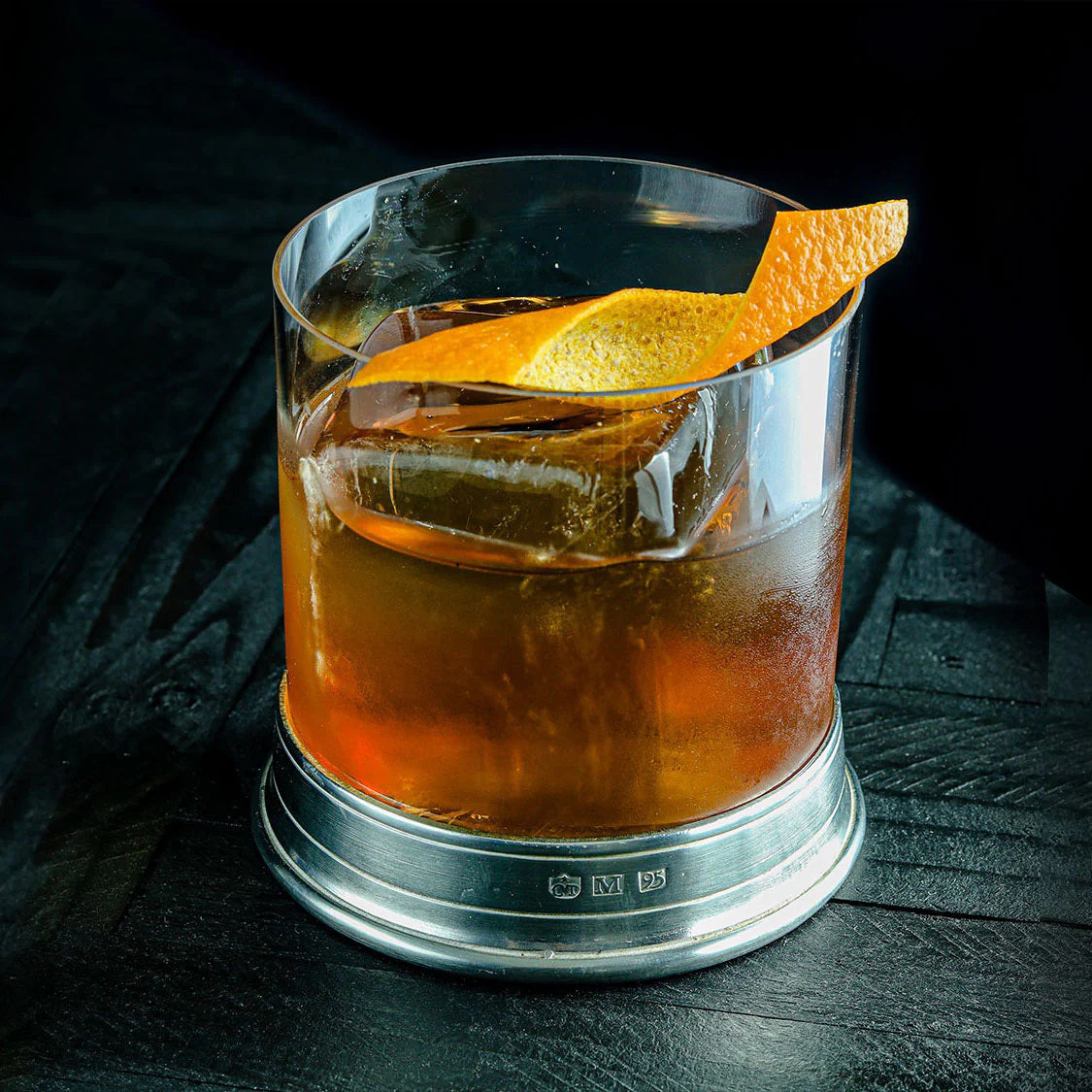 The MATCH - DOUBLE OLD FASHIONED GLASS by MATCH features a clear, wide, short tumbler with an Italian pewter silver base engraved with hallmarks, shown against a white background.