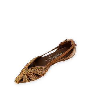 The MEHER KAKALIA - QUEEN DORIS SLING BACK IN KHAKI GOLD is a handcrafted women’s flat sandal in brown and yellow tones, featuring geometric embroidered patterns and cutout details. Viewed from the side, this artisanal footwear by MEHER KAKALIA showcases elegant embroidery and refined styling with a distinctive flair.