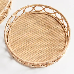 A close-up of the NAPA HOME AND GARDEN Ninette Rattan Round Tray, Small, in light brown with a woven base and decorative interlocking circular rim—ideal for boho decor—set against a plain white background.