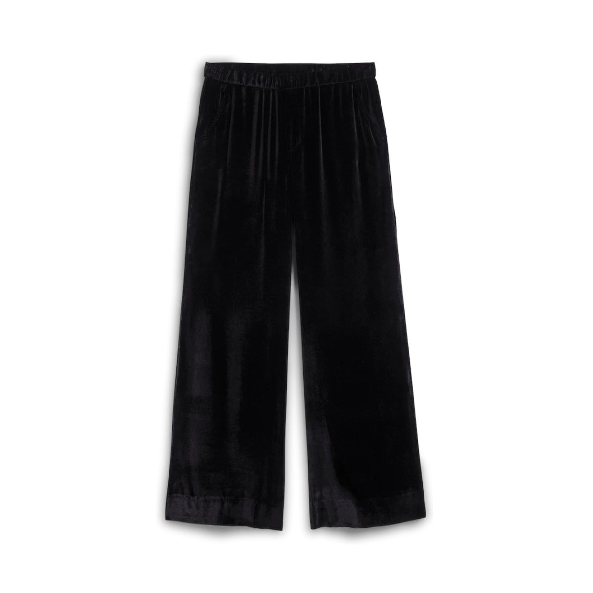 A person indoors wears FRANK &amp; EILEEN's MAISIE Wide Leg Pant in Black Italian Washed Velvet with a white shirt and black pointed-toe heels, standing near a white table topped with books and pink flowers.