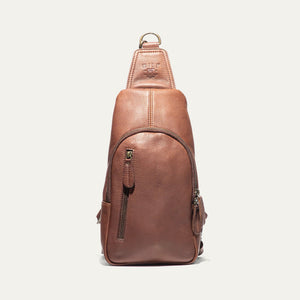 The WILL LEATHER GOODS - Zip Around Sling Bag in Cognac, featuring full-grain leather, a front zipper pocket, adjustable strap, and top handle, is shown upright against a plain light background.