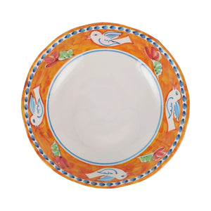 The VIETRI - MELAMINE CAMPAGNA LARGE SERVING BOWL is a durable serving piece that boasts an intricately painted interior. The inner design features a vibrant orange background adorned with colorful flowers and a blue and white bird. A dotted blue pattern graces the rim, making this bowl as functional as it is beautiful.