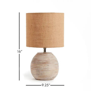 The NAPA HOME AND GARDEN - MADDIE TABLE LAMP features a round, ribbed ceramic base in light beige and a textured brown natural linen shade, adding simple modern style to any room.