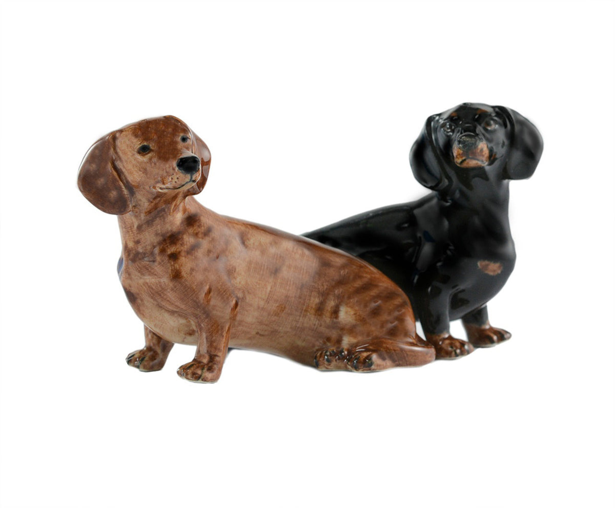 The QUAIL DESIGNS QUAIL CERAMICS Dachshund Salt and Pepper Set features two hand-painted stoneware figurines, one brown and one black, side by side on a white background. Dishwasher safe for easy care.