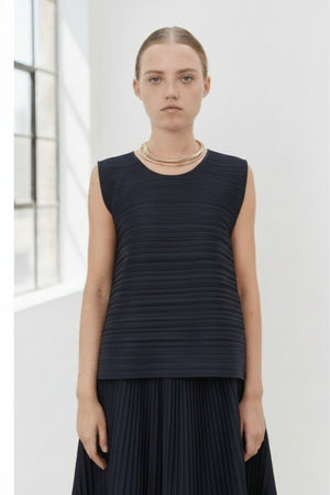 Close-up of MEIMEIJ Plisse Sleeveless Top's dark textured fabric displays a finely woven pattern. The consistent monochrome color and texture, with subtle weave variations, reflect minimalist elegance.
