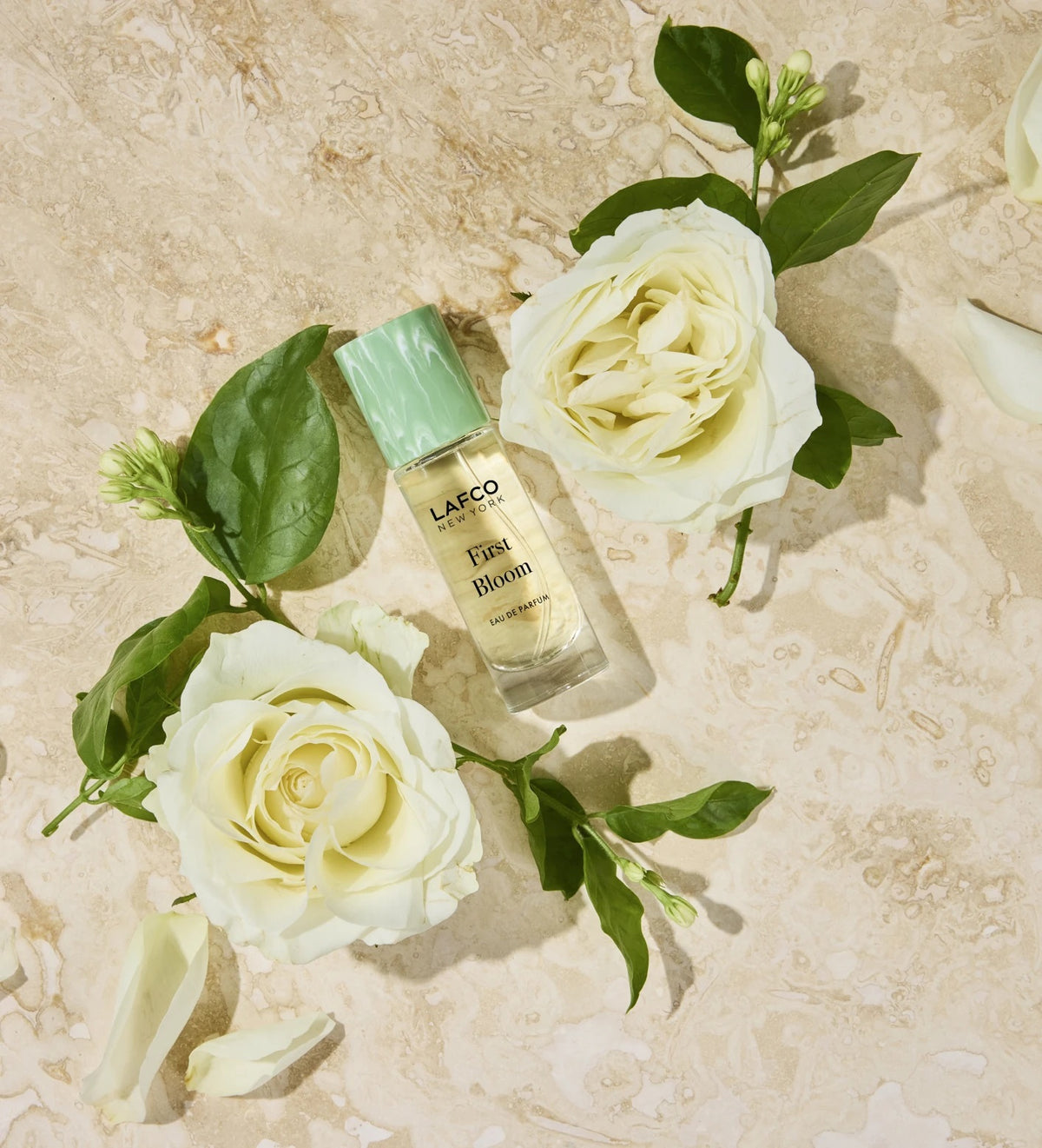 A 10ml bottle of LAFCO Fine Fragrance, First Bloom, a vegan eau de parfum that captures the freshness of spring with luminous neroli and radiant floral notes. Presented by LAFCO, this scent features a marbled green and white cap atop vibrant yellow liquid.