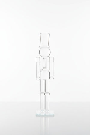 ZODAX GLASS DECOR NUTCRACKER 16″ clear glass figurine standing on a square base, resembling the elegant silhouette of a 16-inch glass vase.