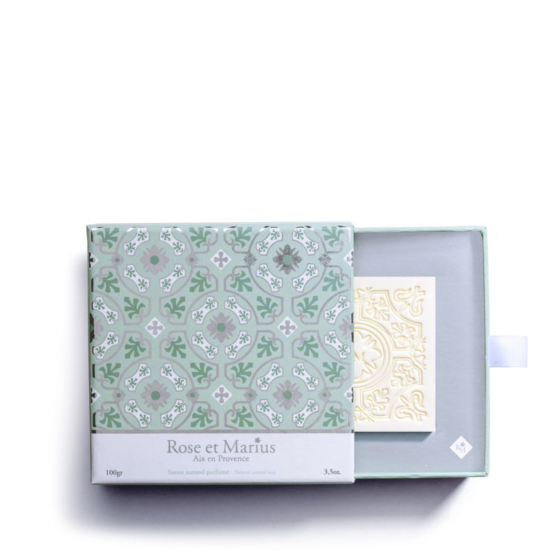 The ROSE ET MARIUS &quot;A Summer Night Under the Figtree&quot; scented solid soap gift box features a white square bar embossed with elegant floral and geometric patterns, reflecting artisan craftsmanship, photographed on a plain white background.