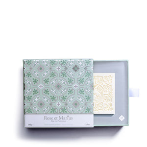 The ROSE ET MARIUS "A Summer Night Under the Figtree" scented solid soap gift box features a white square bar embossed with elegant floral and geometric patterns, reflecting artisan craftsmanship, photographed on a plain white background.