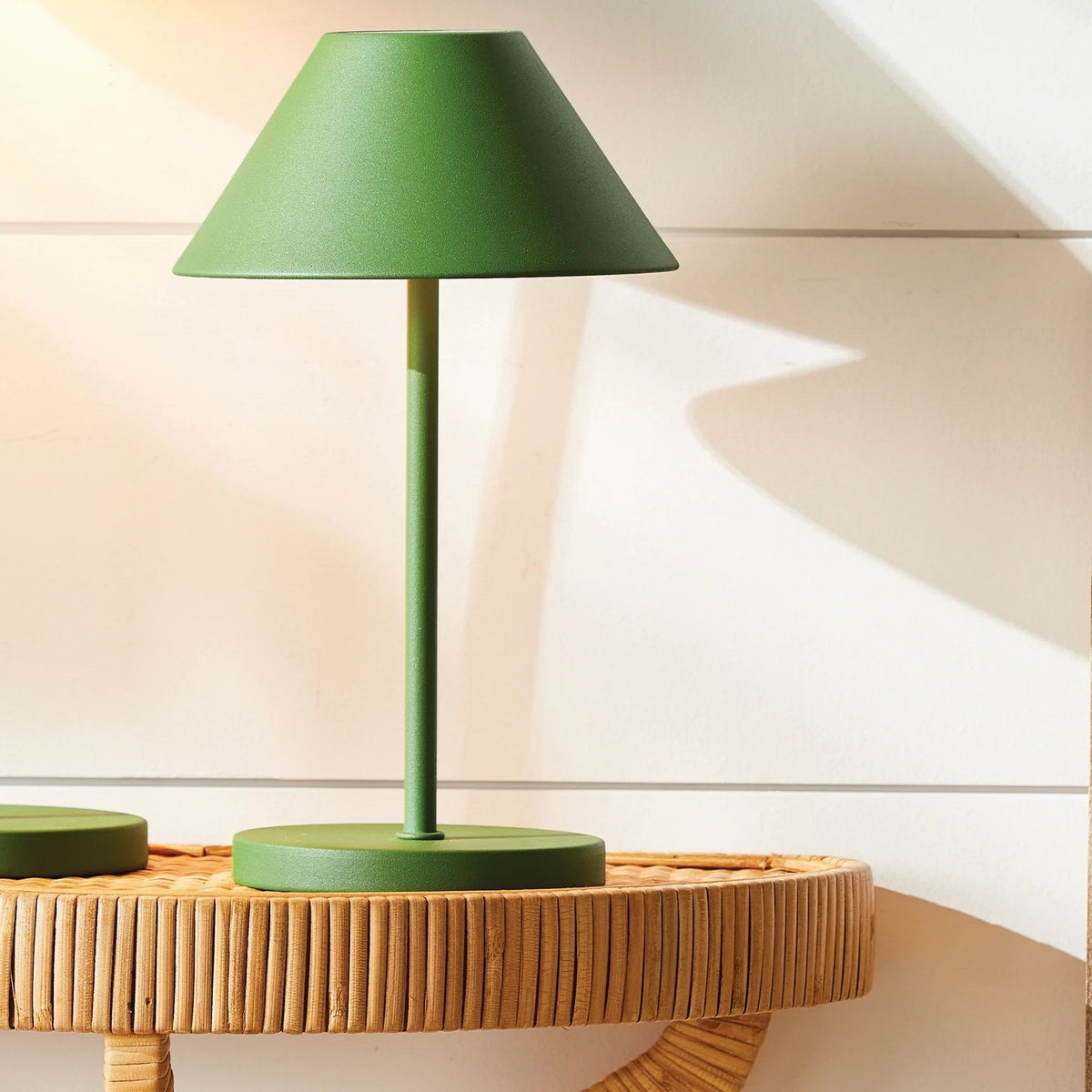 The NAPA HOME AND GARDEN - ALLUNA 10” Cordless LED Lamp in green, a compact and modern luxury table lamp featuring a metal conical shade and a round base, is displayed against a plain white background.
