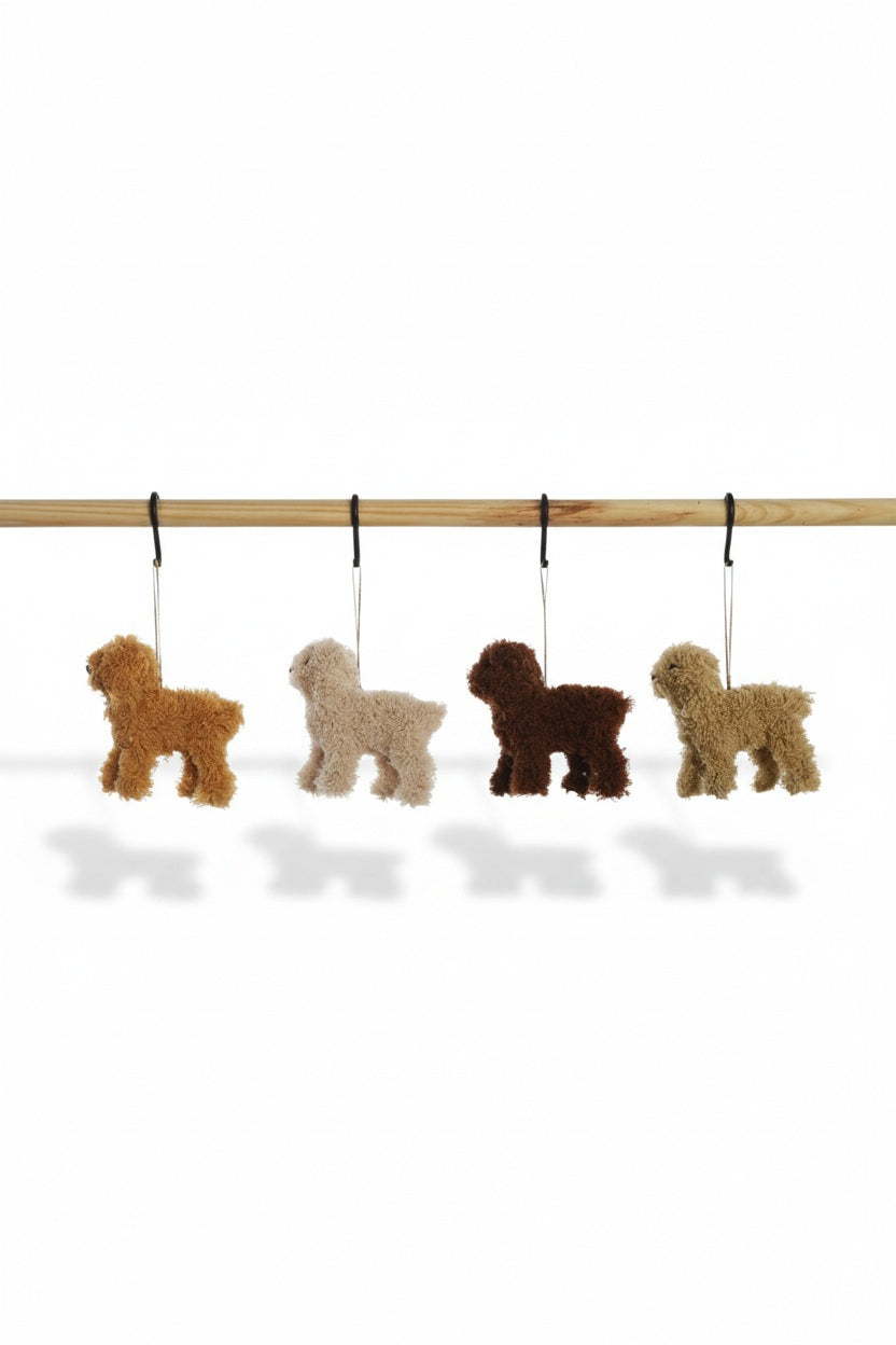 Four FURRY POODLE ORNAMENTs in shades of brown and tan hanging from a wooden rod.