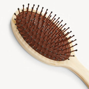 The MACHETE Everyday Detangling Hair Brush in Alabaster features an ivory marbled Italian acetate design, oval head, and curved handle with concealed bristles, shown from above on a plain white background.