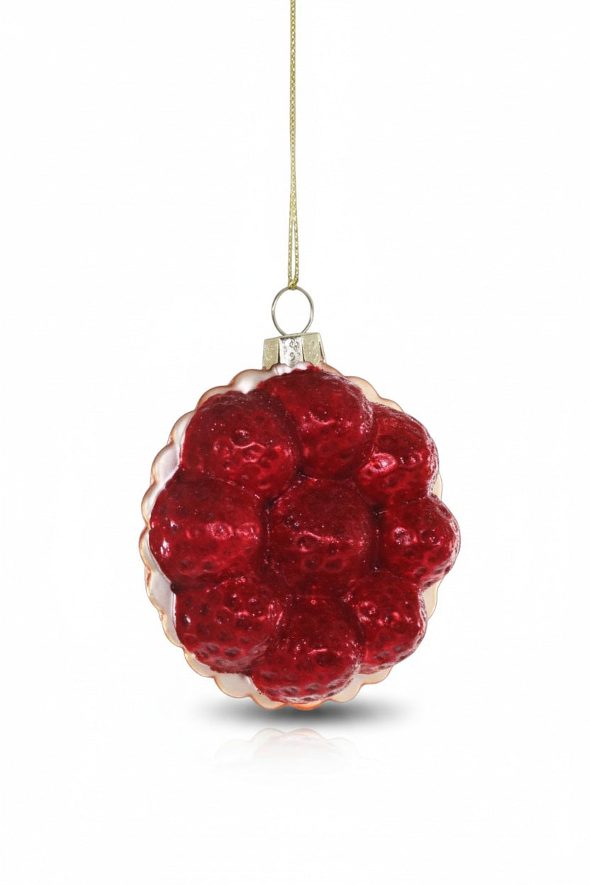 The CODY FOSTER STRAWBERRY TART ORNAMENT, featuring glossy red berries and a gold string, is a charming collectible or a unique gift for design lovers.