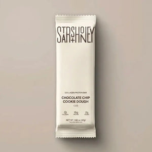 A STARS+HONEY - CHOCOLATE CHIP COOKIE DOUGH protein bar is displayed in white packaging against a neutral background, with the label emphasizing its unique protein blend featuring 15g of protein, only 2g of sugar, and added collagen for a delicious and nourishing snack.