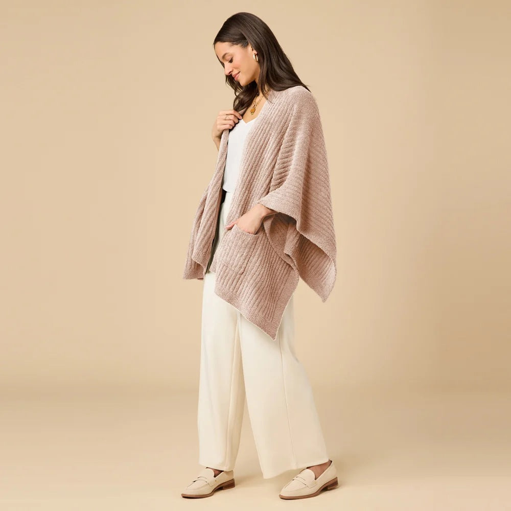 A woman wearing a black SOFTIES - SOLID RIB MARSHMALLOW SHAWL over a grey top and white trousers.
