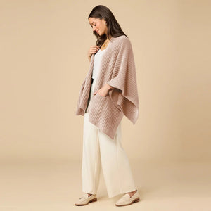 A woman wearing a black SOFTIES - SOLID RIB MARSHMALLOW SHAWL over a grey top and white trousers.