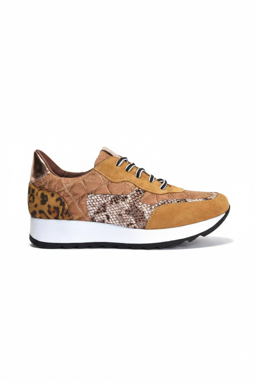 The CORDANI Lizzie Sneaker by CORDANI showcases a stylish leopard print design with brown and tan animal print panels, complemented by black and white laces and finished with a thick white sole featuring a black wavy tread, all set against a plain light background.