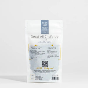 A white pouch labeled “THE CHAI BOX - DECAF ALL CHAI’D UP” from THE CHAI BOX contains an organic spiced tea blend crafted with naturally decaffeinated black tea. The package indicates it yields 20-25 cups and is hand blended on the Atlantic Coast.
