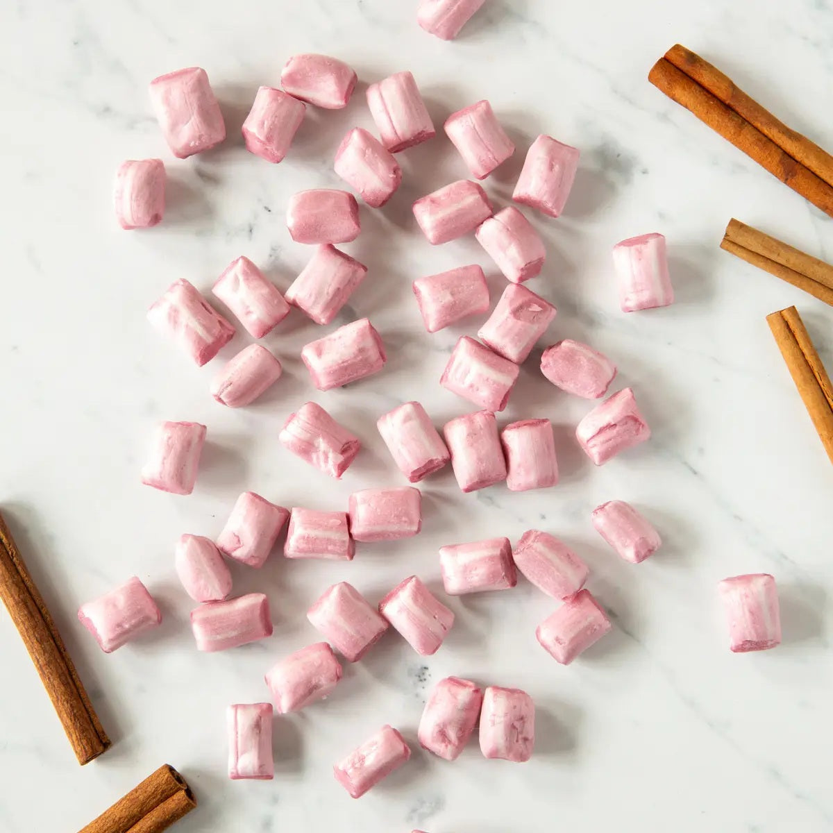 A white pouch of BUTTERFIELDS - CINNAMON BUDS hard candy by BUTTERFIELDS features an illustration of cinnamon sticks and leaves, capturing the inviting warmth of holiday spices. The packaging includes a gluten free label, a small image of the candy, and lists a net weight of 2.5 oz (71g).