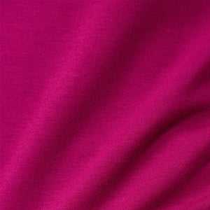 A woman seen from behind wearing the fuchsia SOFTIES - DREAMTECH COWL NECK WITH PLEATED PANT set featuring a long-sleeved cowl neck top and matching pleated pants.
