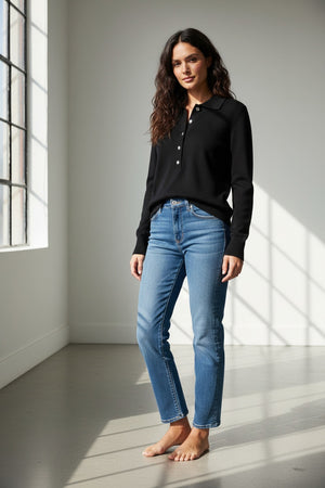 A person wearing the KINROSS CASHMERE Crystal Button Cashmere Polo in black by KINROSS, paired with blue jeans, stands facing forward against a plain white background.