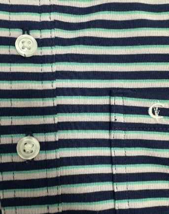 The CRIQUET Performance Players Shirt in Duval Stripe—Navy features neatly folded navy and white horizontal stripes, a collar, and a front pocket, showcased on a black background.