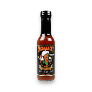 A 5 fl oz (150 ml) bottle of CACKALACKY - JACK PEPPER SAUCE GOLD by CACKALACKY, featuring a black label with a cartoon pepper in a chef’s hat, plus white, orange, and green text. This is an all-natural hot sauce.